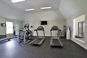 A gym with treadmills, elliptical machines, and other exercise equipment.